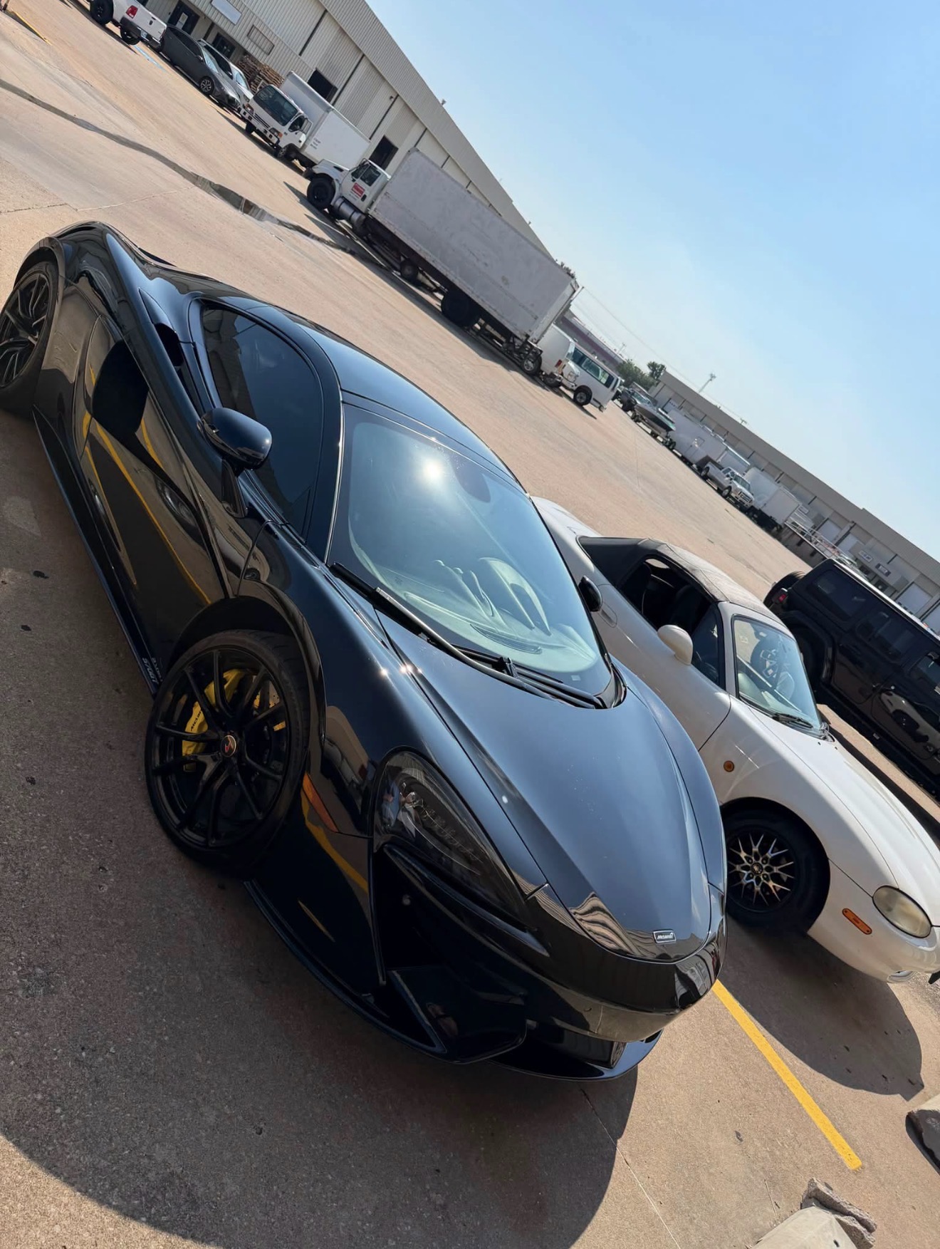 Black McLaren sports car parked outside Insanity Customs
