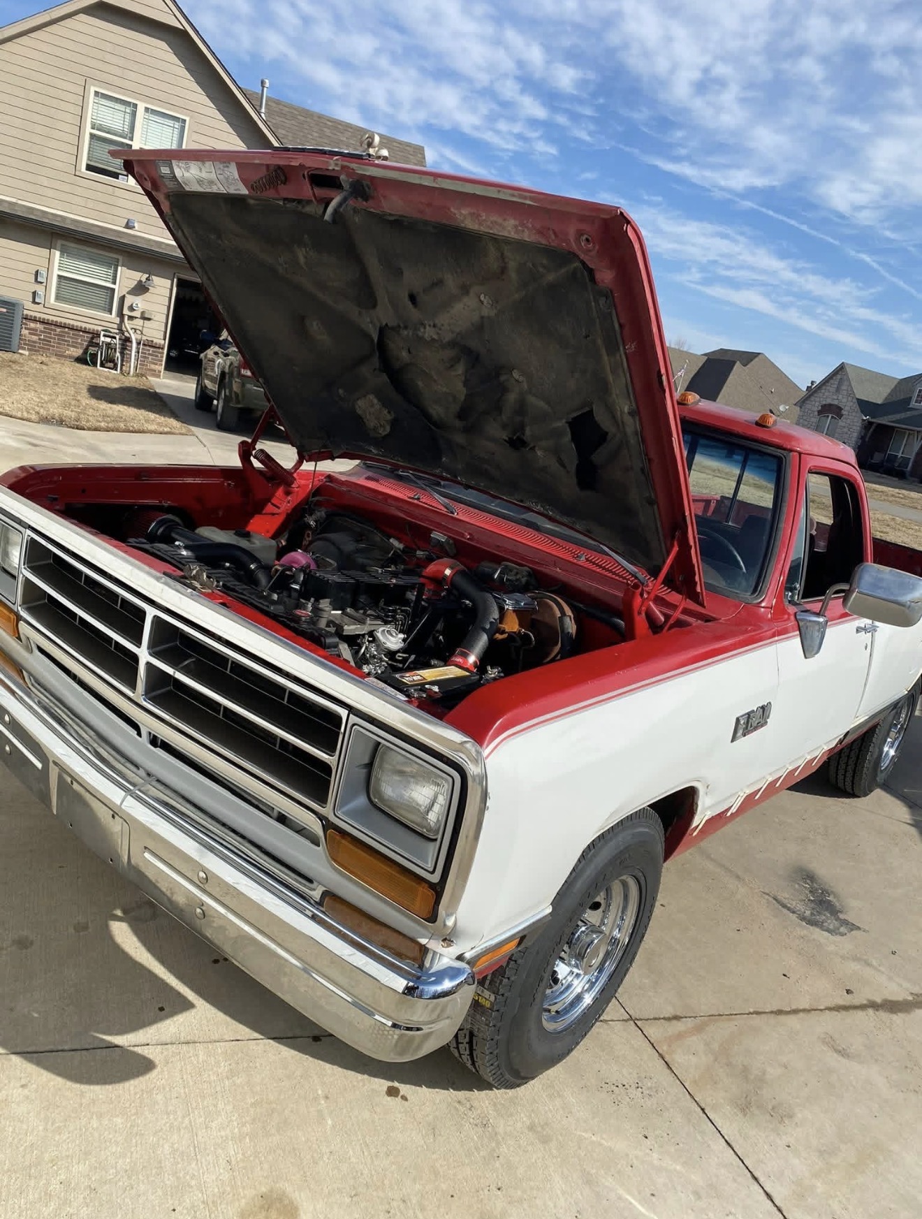 Two-tone 1980s Dodge D150 pickup with a modern engine swap under the hood